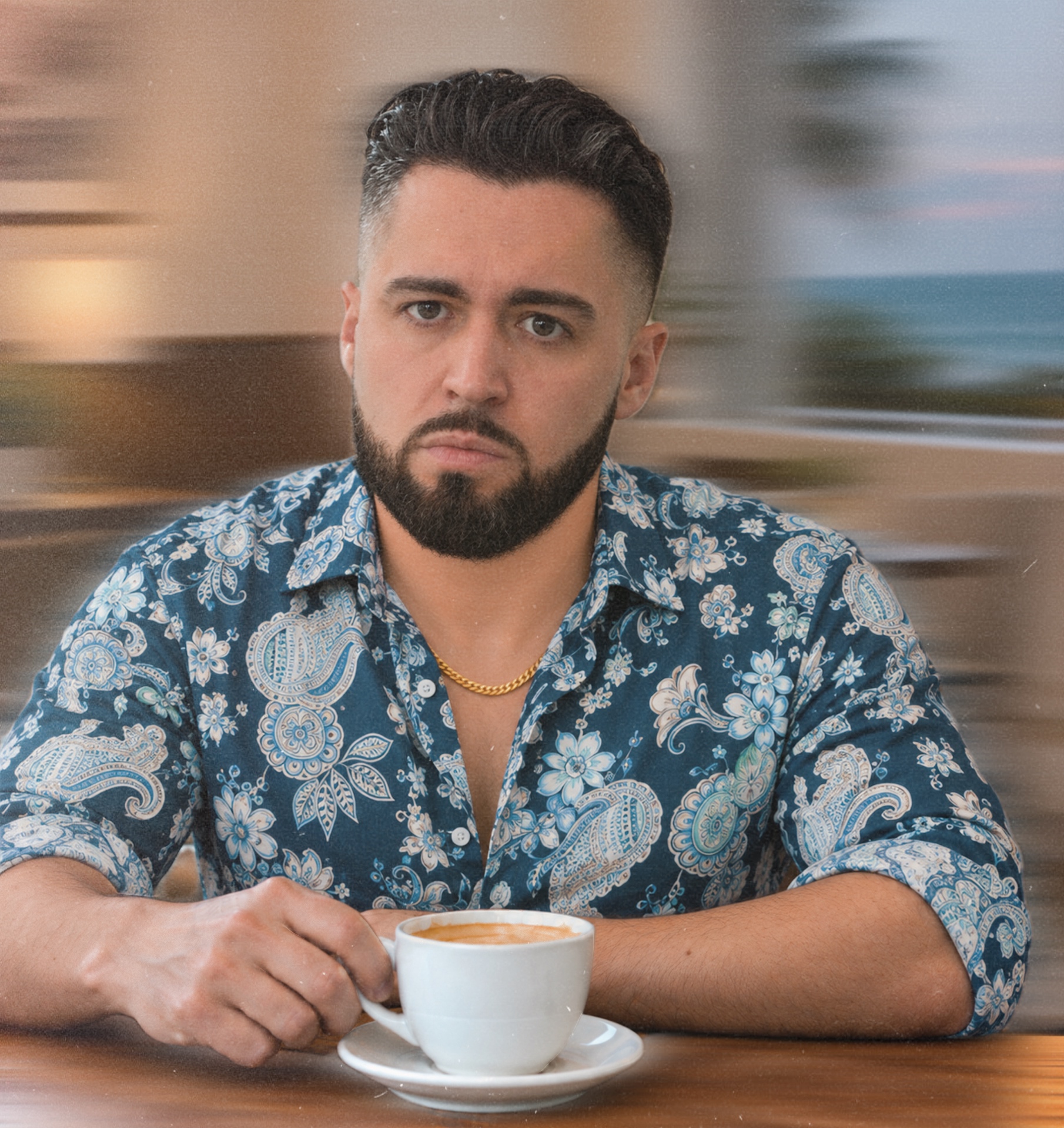 Aaron Ernst seated at a café table with a cup of coffee